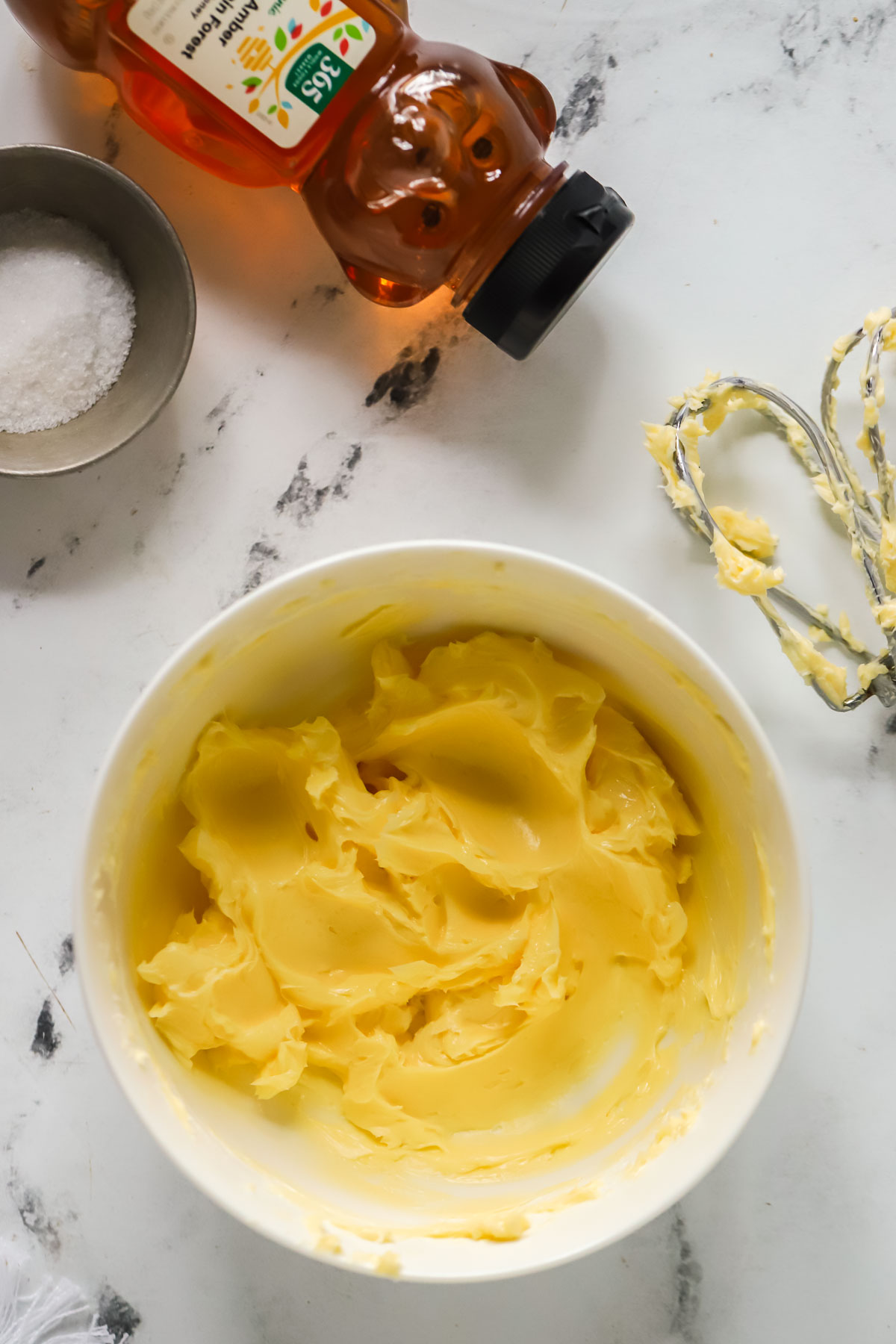 creamed butter in a bowl, a honey bear, dish of salt