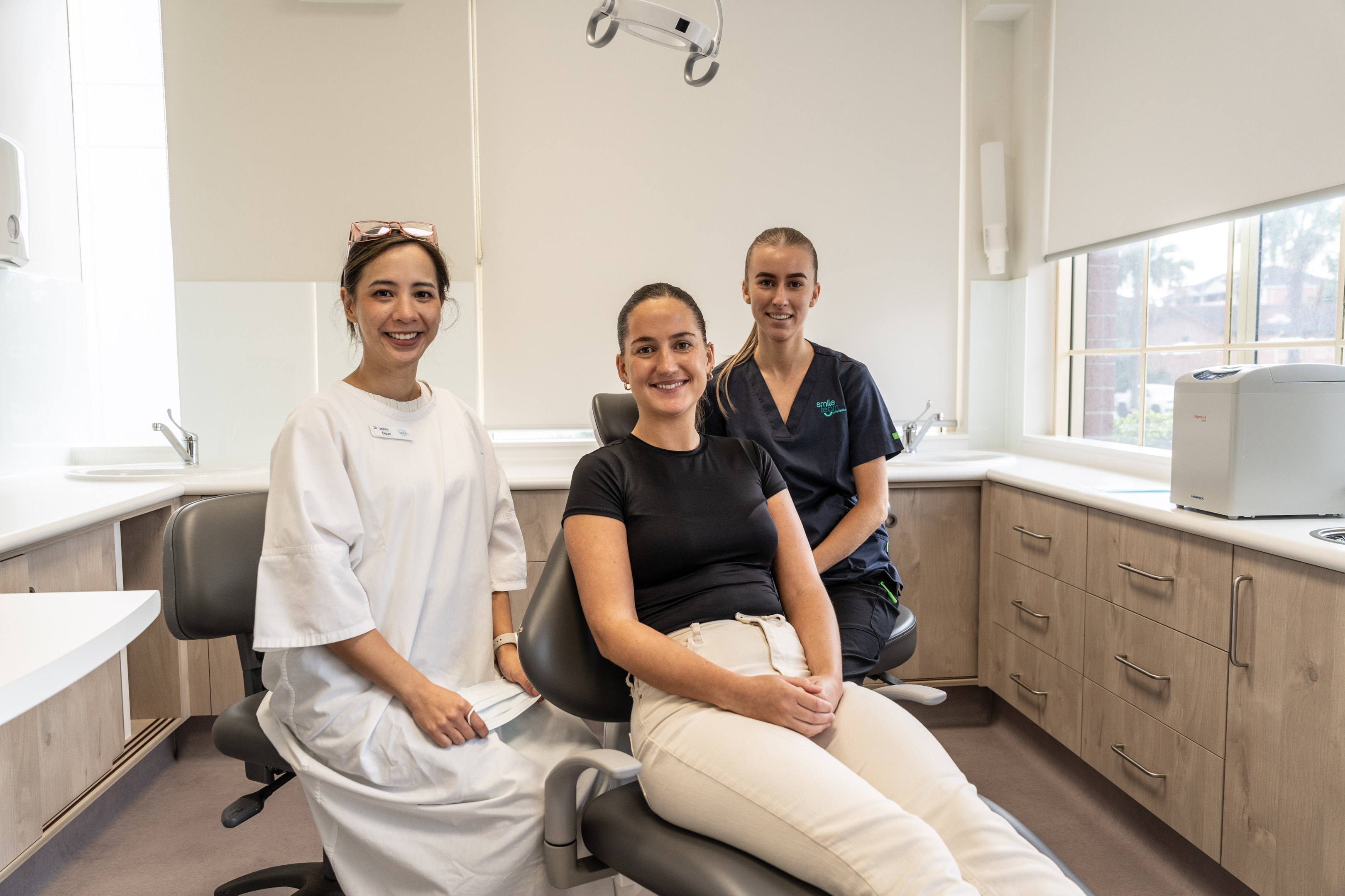 Female orthodontist with young female patient and young female nurse