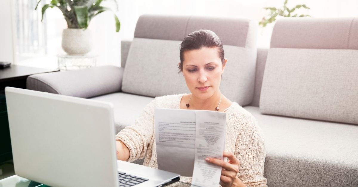 Woman reviewing tax documents on a laptop to ensure accurate pay excise tax compliance.