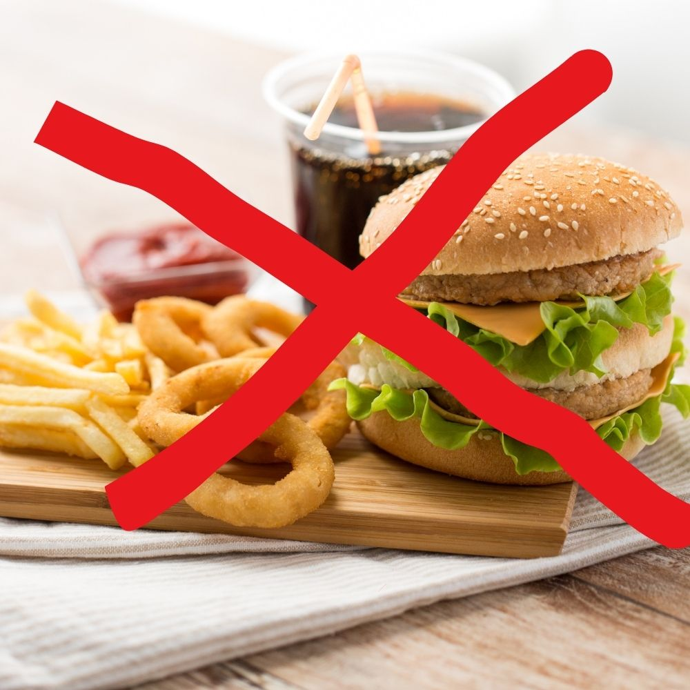 An image of a plate with a red cross over processed foods, sugary drinks, and high-fat snacks, which are what not to eat on semaglutide for maintaining a balanced diet.