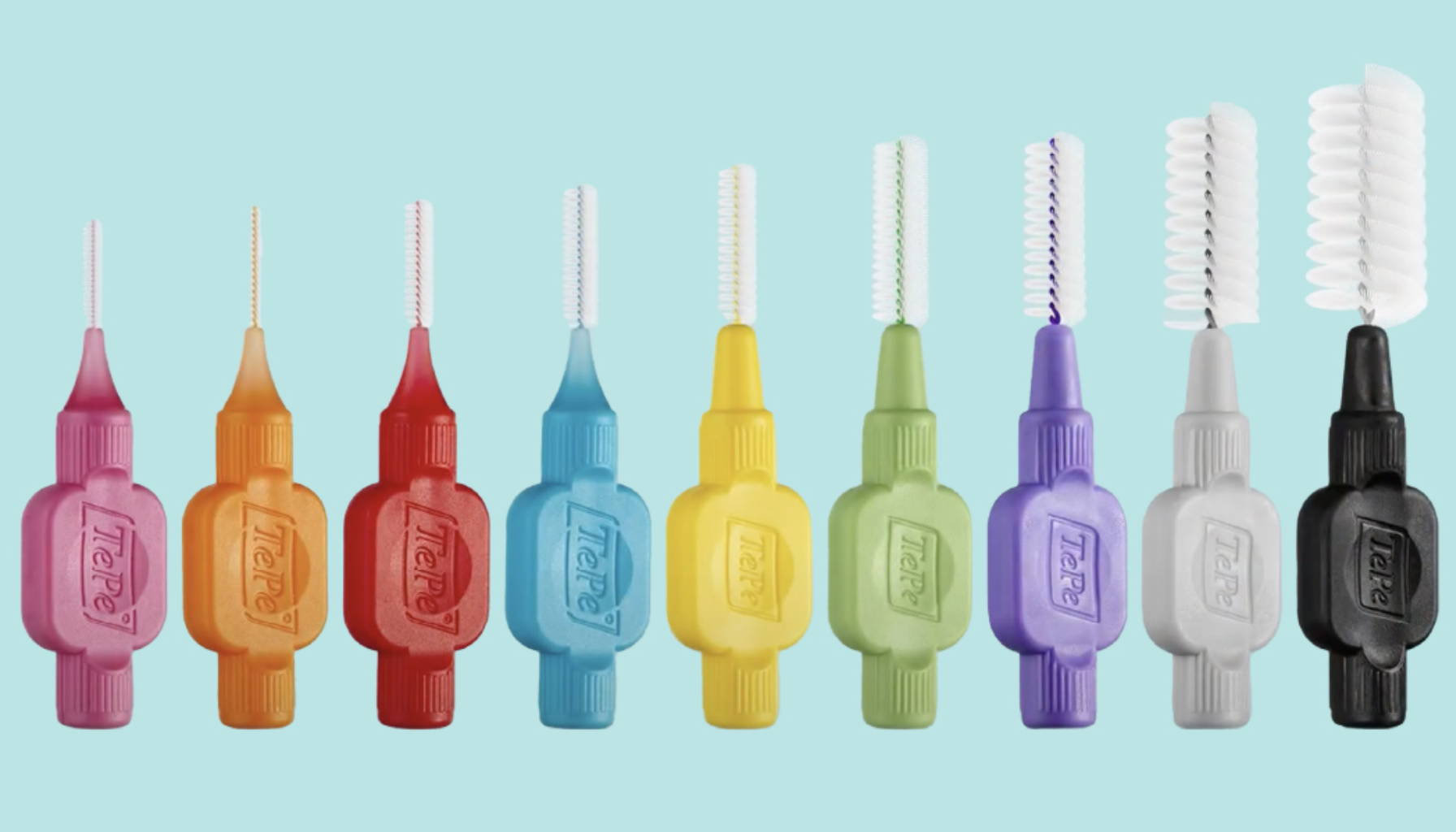 Rengjøringsbørste for tenner: Liten børste stor forskjell 11 Fargerike mellomromsbørster står på rekke mot lys blå bakgrunn og viser ulike størrelser for tannrengjøring.