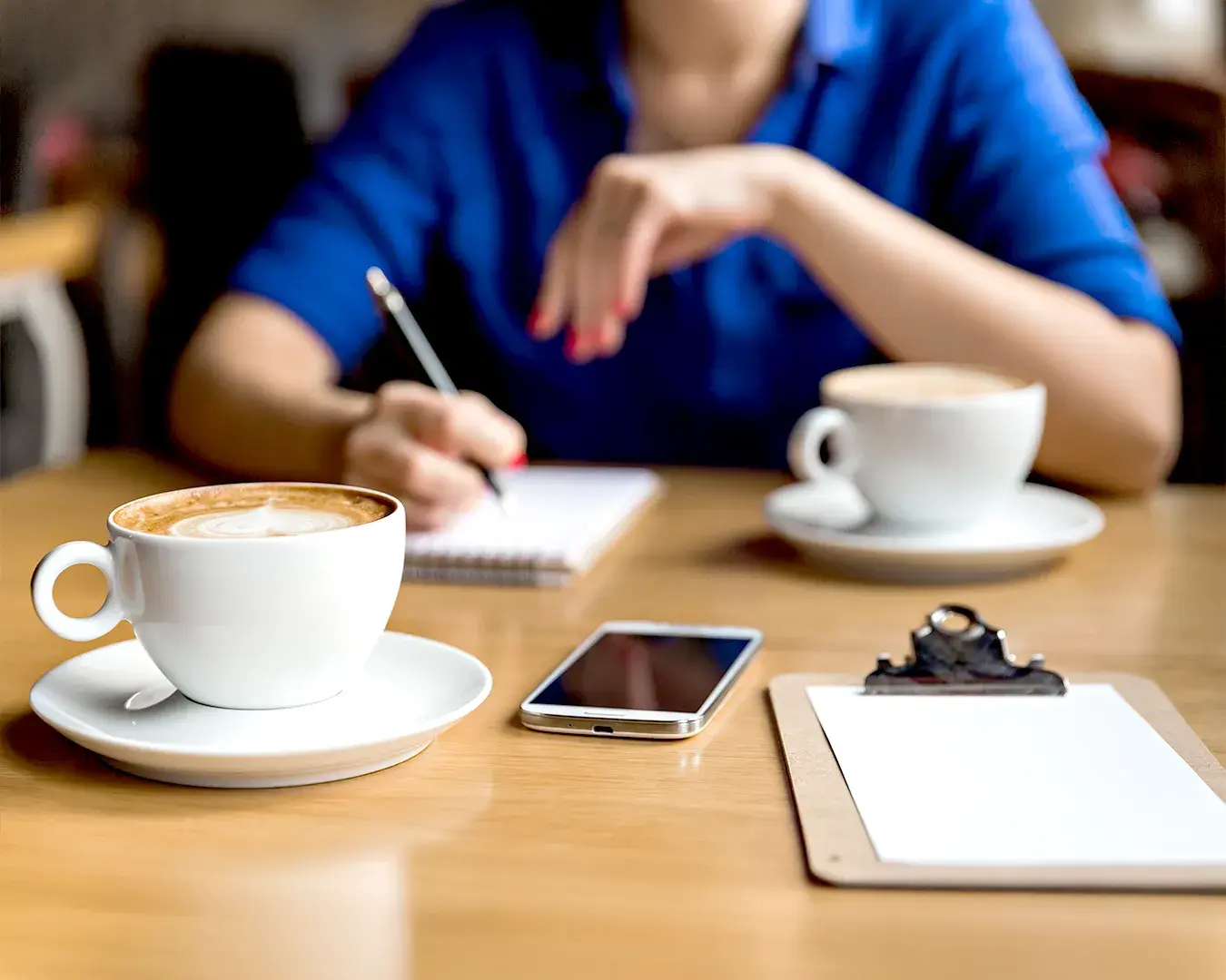 Restaurant marketing planning session with coffee, notebook, smartphone and laptop in professional café setting
