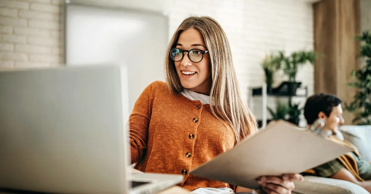 A woman at her laptop reading about OnlyFans tax deductions.