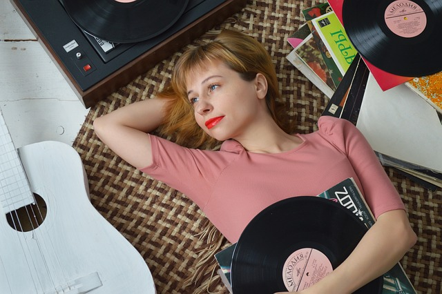 A person holding a vinyl record with a smile