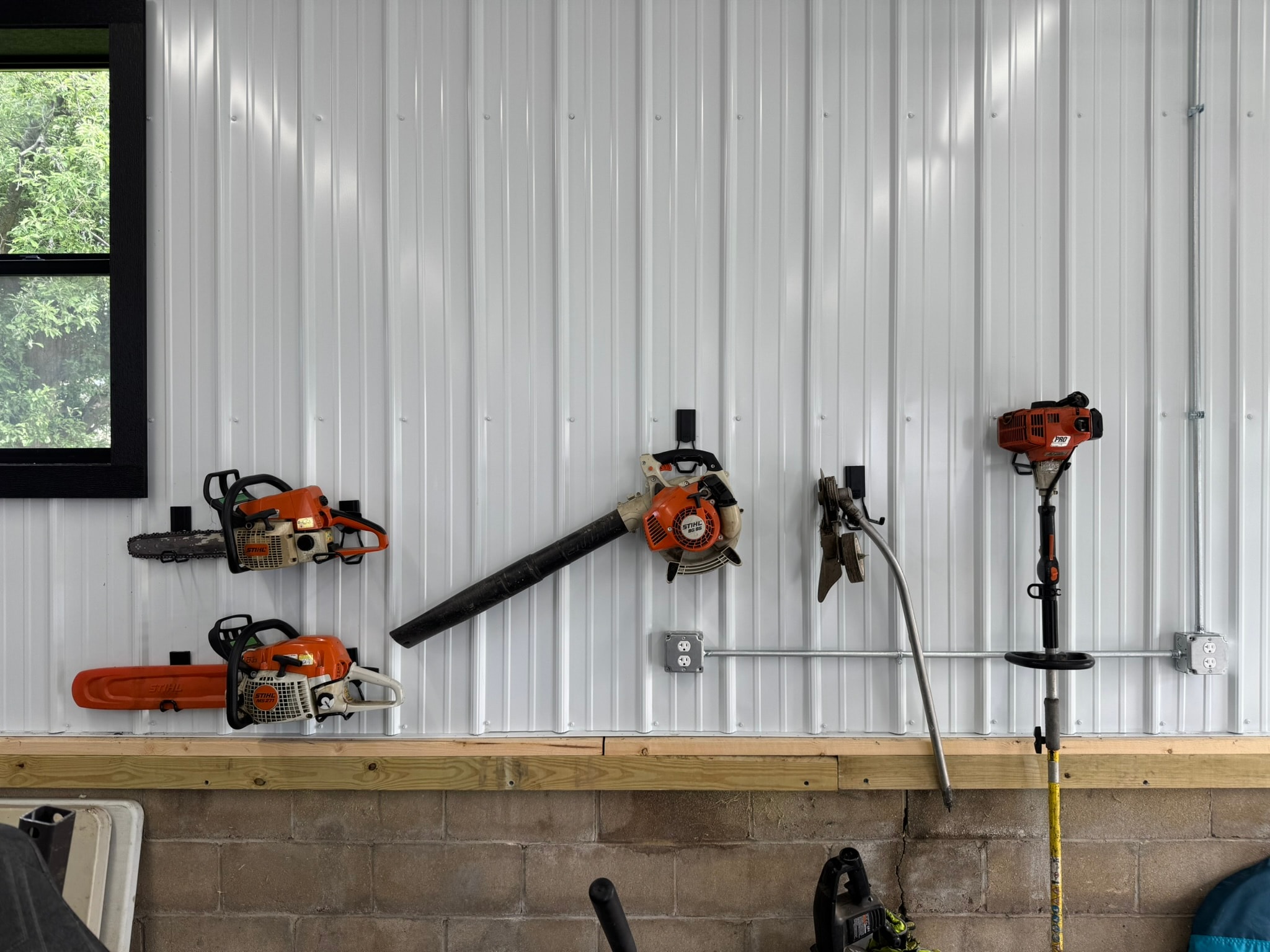 STIHL Blower, Trimmer and Chainsaws hanging on Gator Magnetics Hooks on a steel pole barn wall