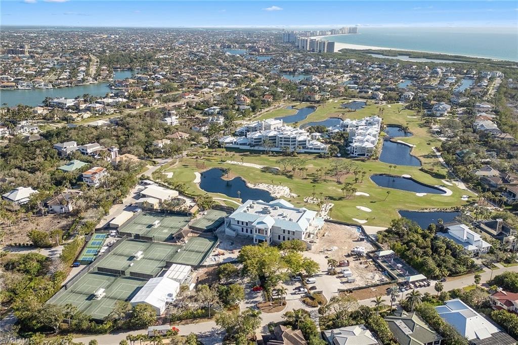 An aerial view of the Marco Island golf course showcases luxury homes overlooking emerald fairways and the Gulf waters, highlighting the scenic beauty of this prime location. The image captures the essence of coastal living, with expansive outdoor terraces and stunning backdrops that define the lifestyle of golf course communities in Marco Island.
