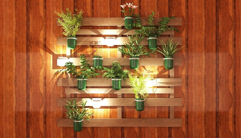 Indoor wall grazing lights illuminating a wooden vertical plant display