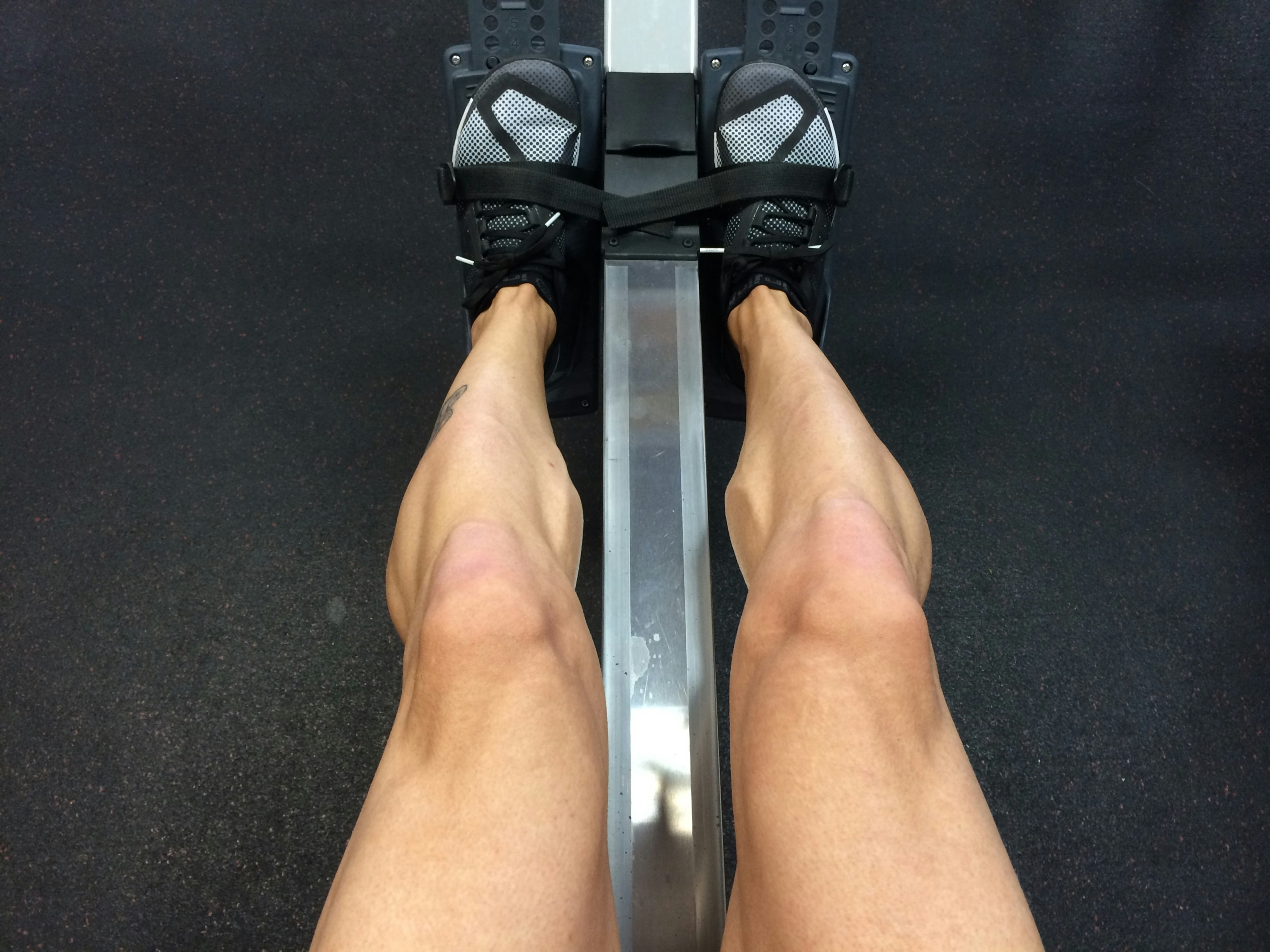 Muscular legs sat at a rowing machine