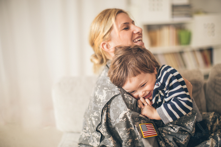 Female veteran holding her young son. 