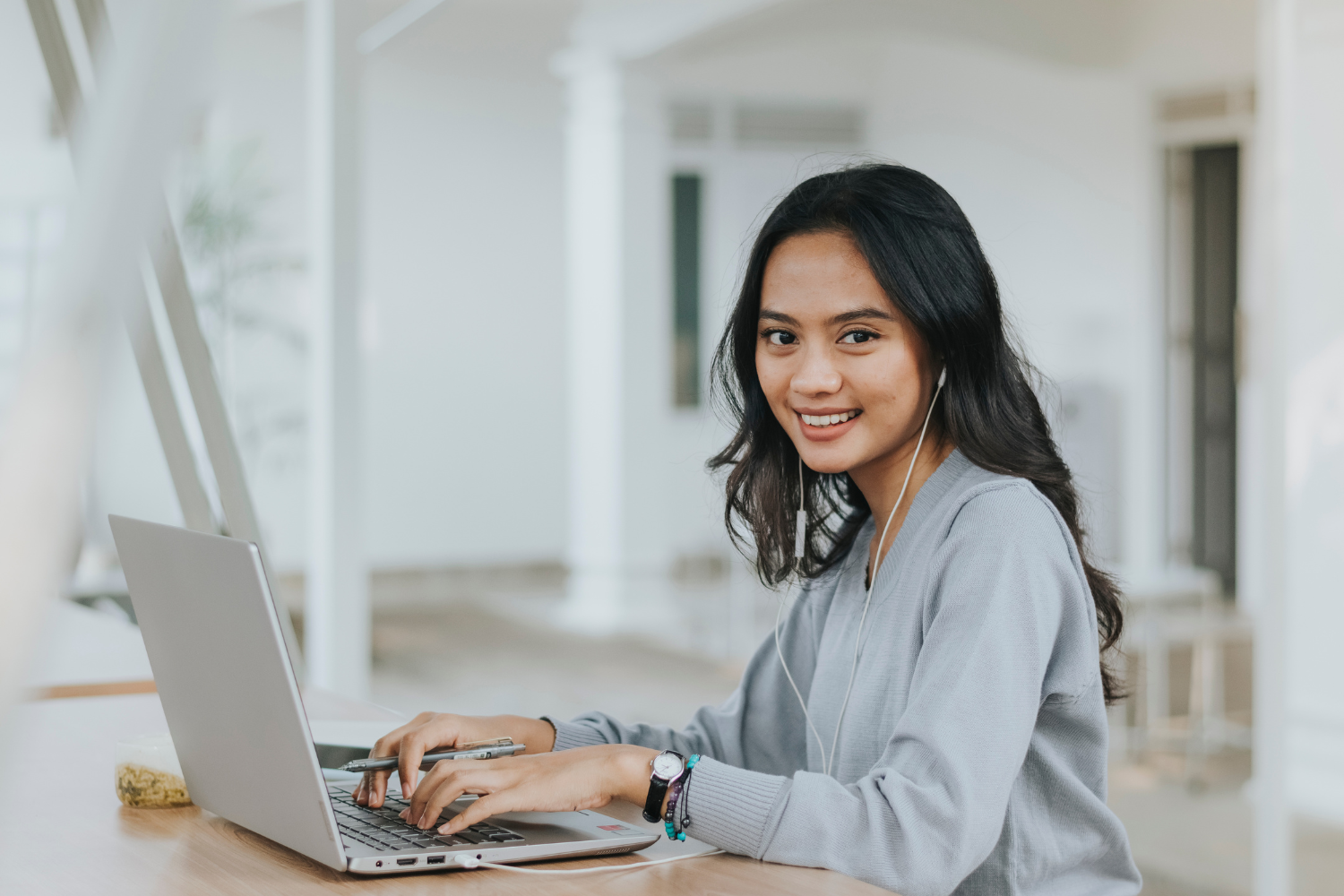 Filipino worker smiling while working at laptop.