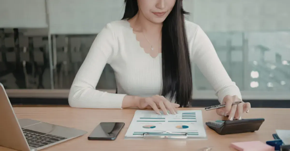 Woman reviewing an IRS tax notice and calculating IRS penalties and interest on unpaid taxes.