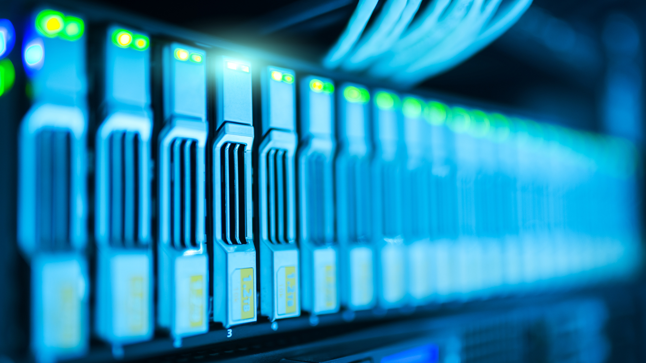 Close-up of server racks with glowing green and blue indicators, symbolizing high-performance data storage solutions.