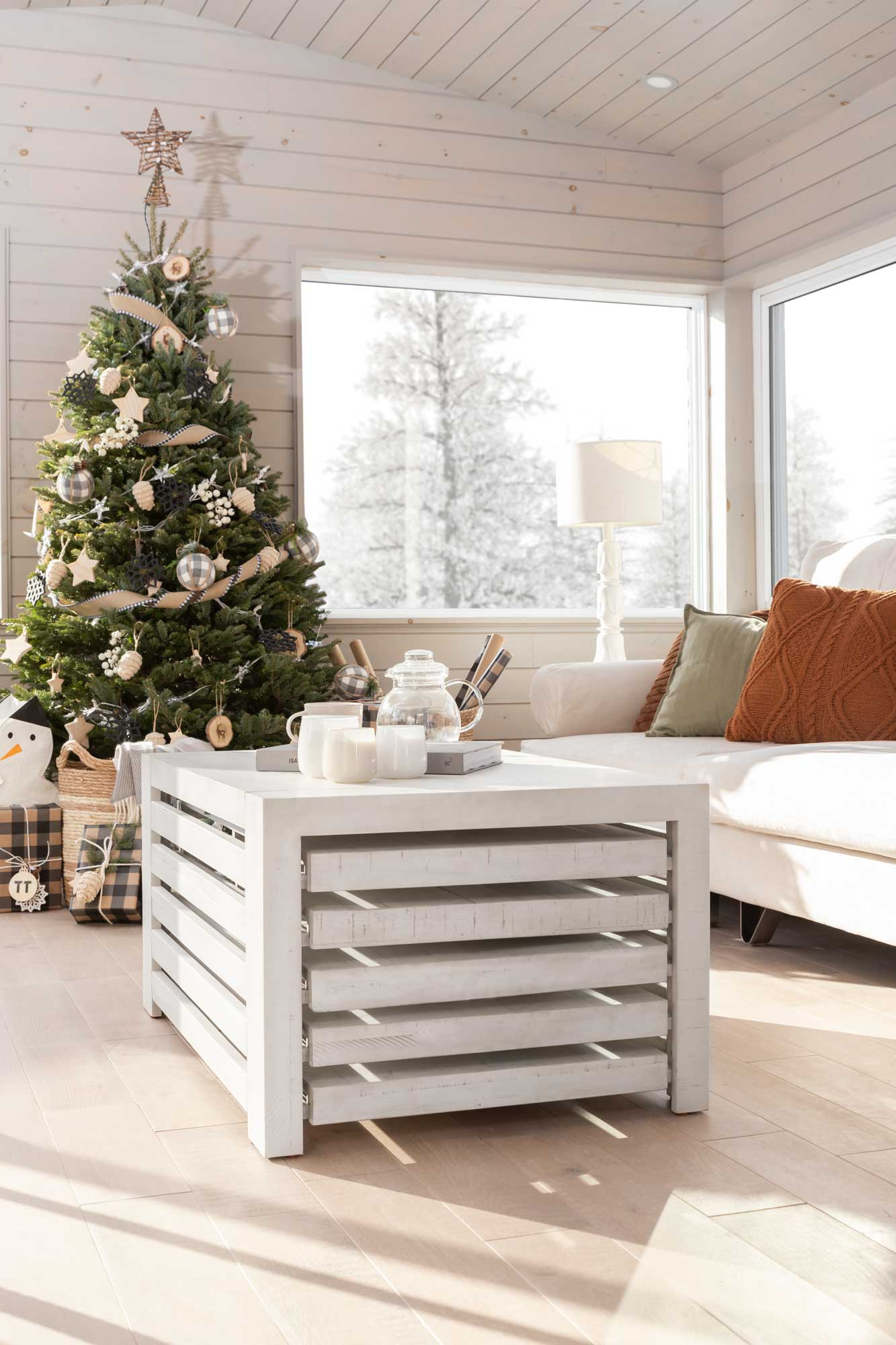 A Christmas tree in a living room with a coffee table