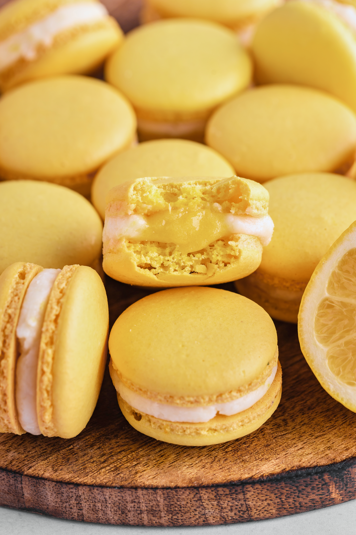lemon macaron filled with lemon curd and a bite taken out of it