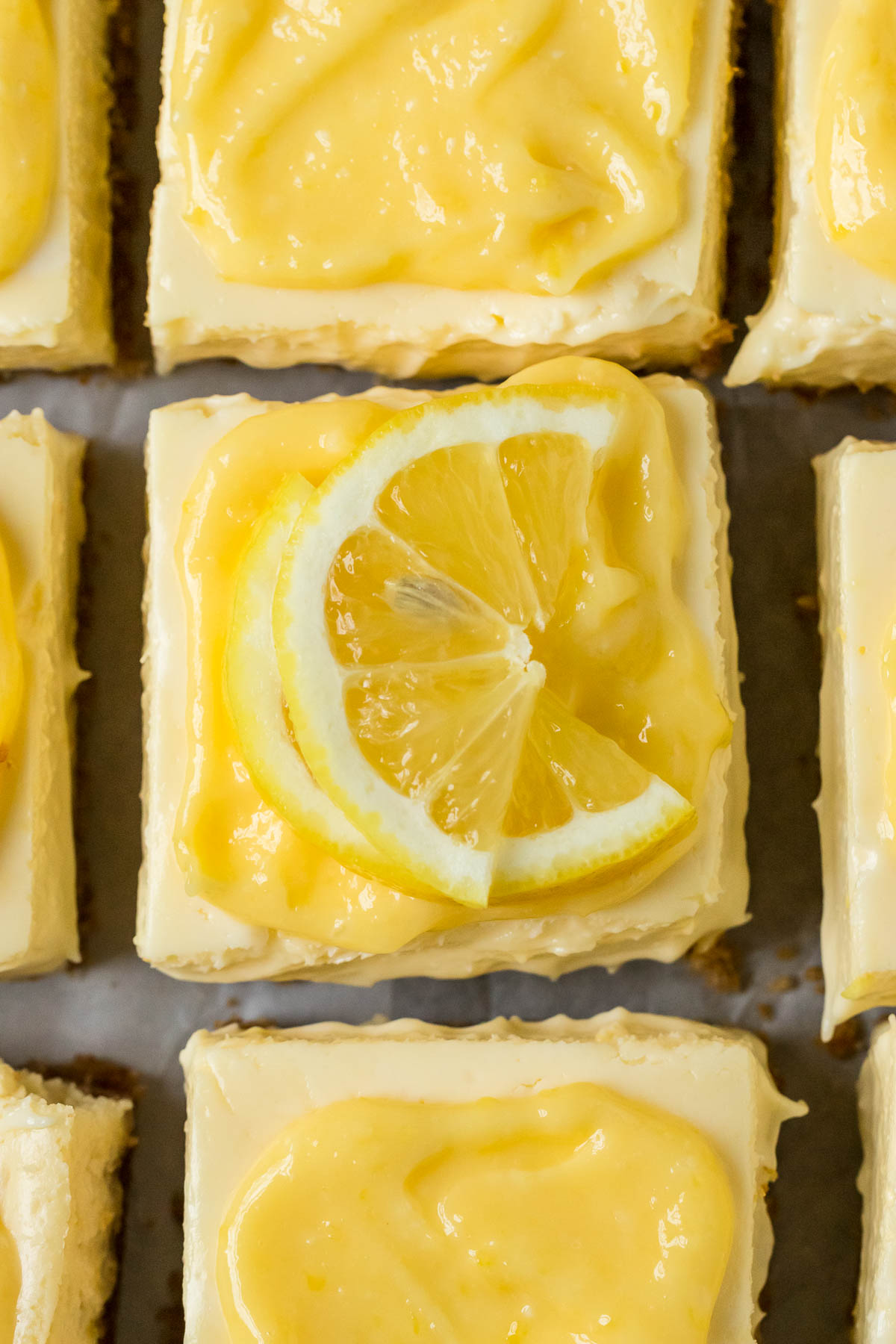 lemon cheesecake bar topped with curd and lemon slices