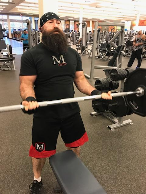 strong bearded man curling heavy weight