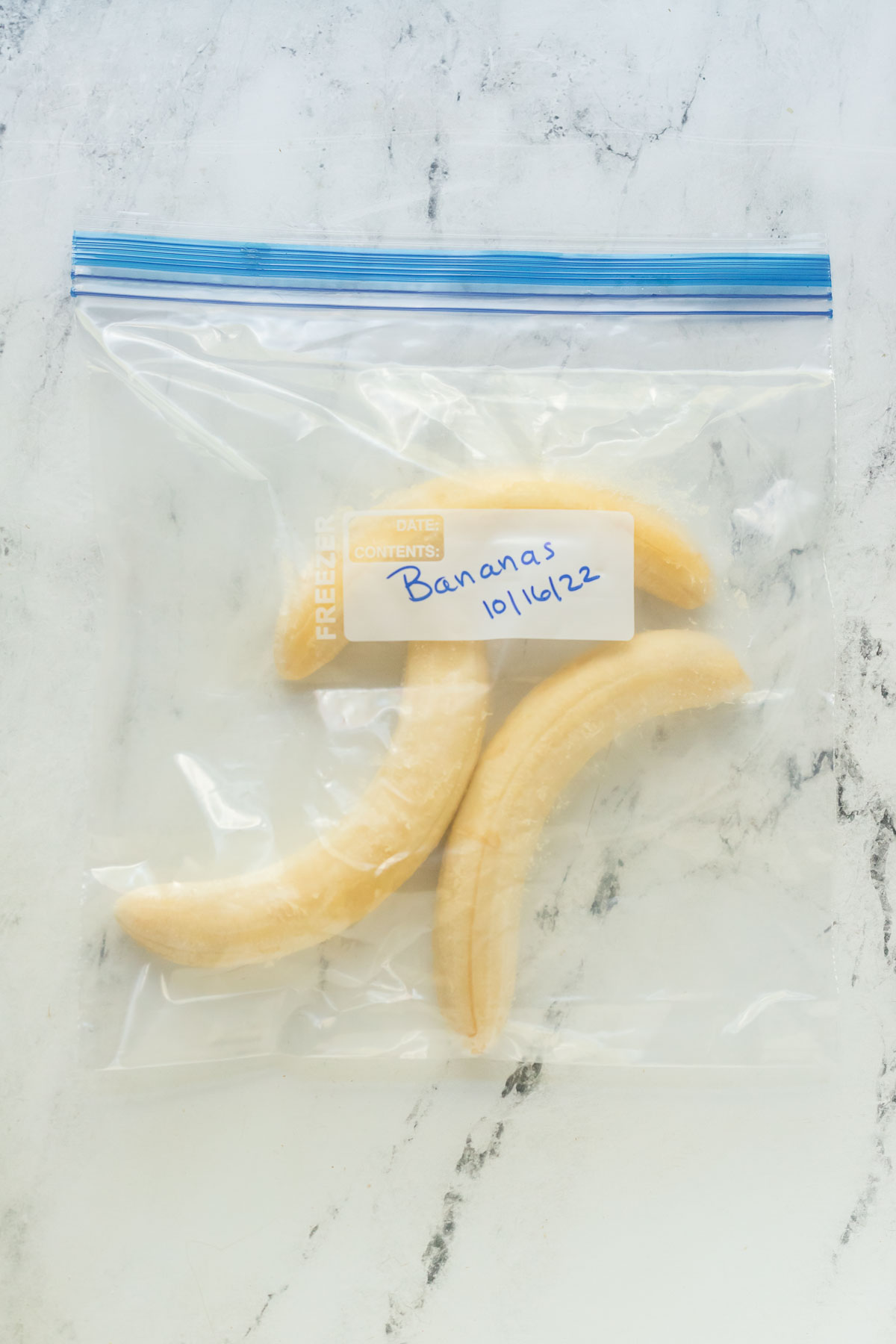 freezer bag with three frozen bananas in it