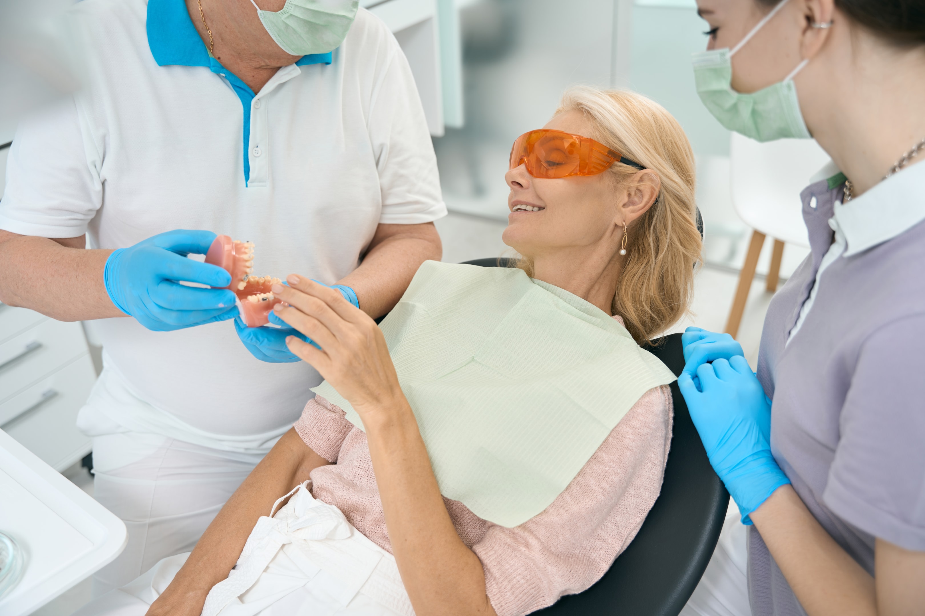 female dental patient being shown a dental implant calgary ab model