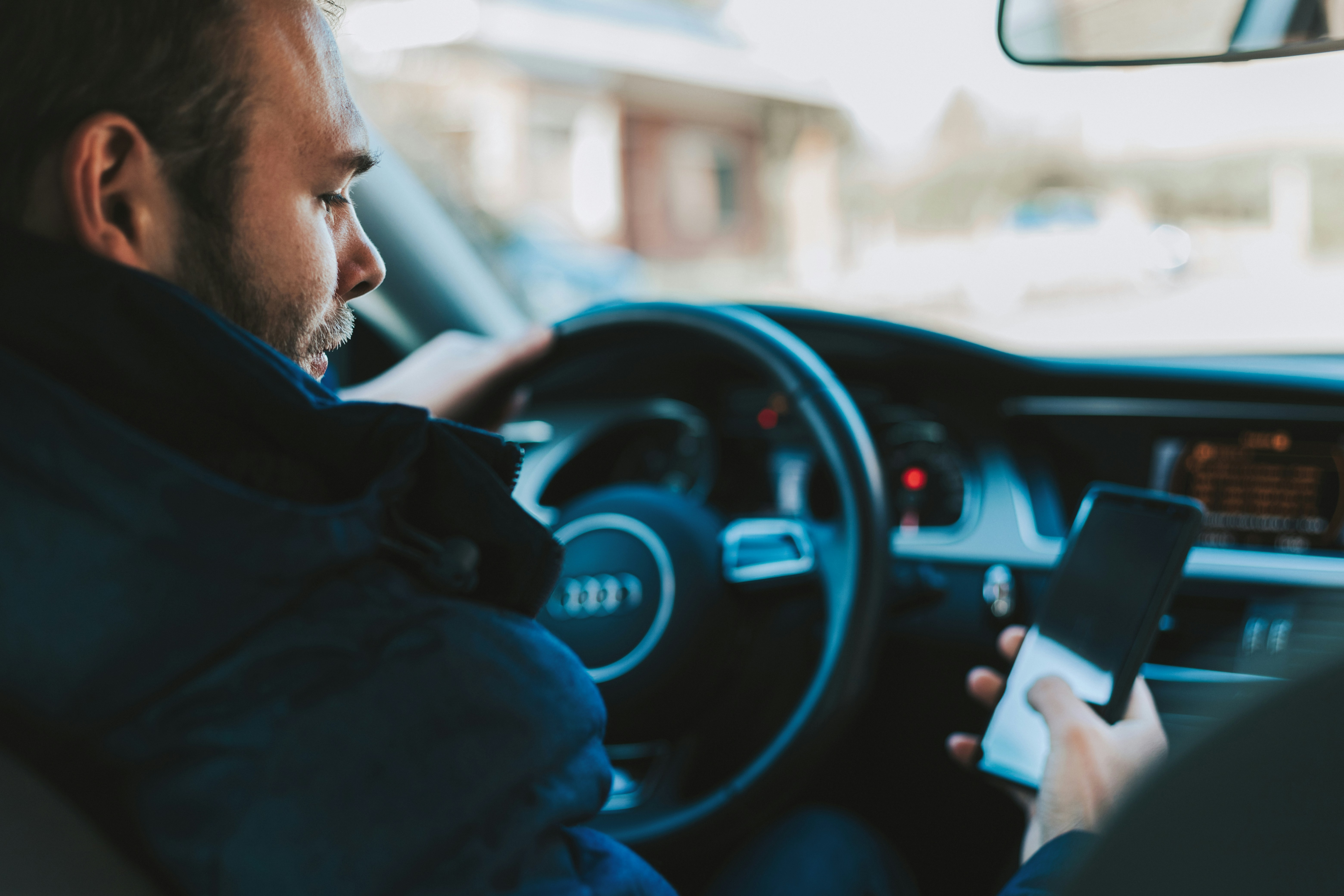 man using smartphone while driving