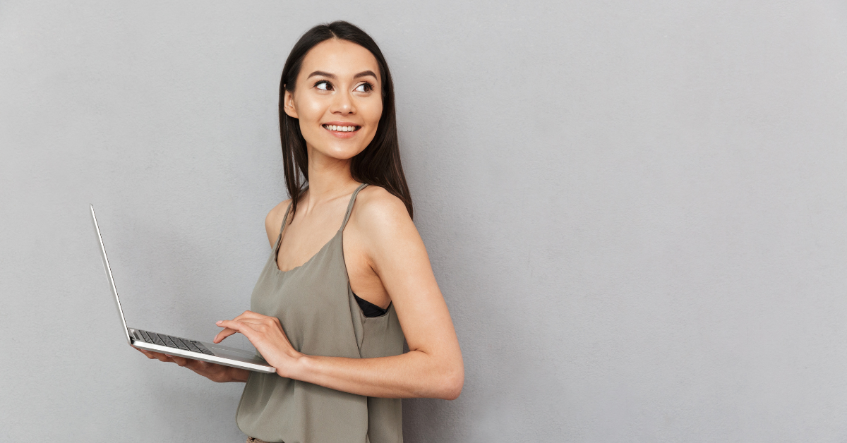 A smiling woman holding a laptop, confidently mastering the steps to handle OnlyFans taxes efficiently.