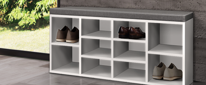 An Artiss White and Grey Storage Bench holding three pairs of shoes, in a room with a light wood floor and concrete wall.  