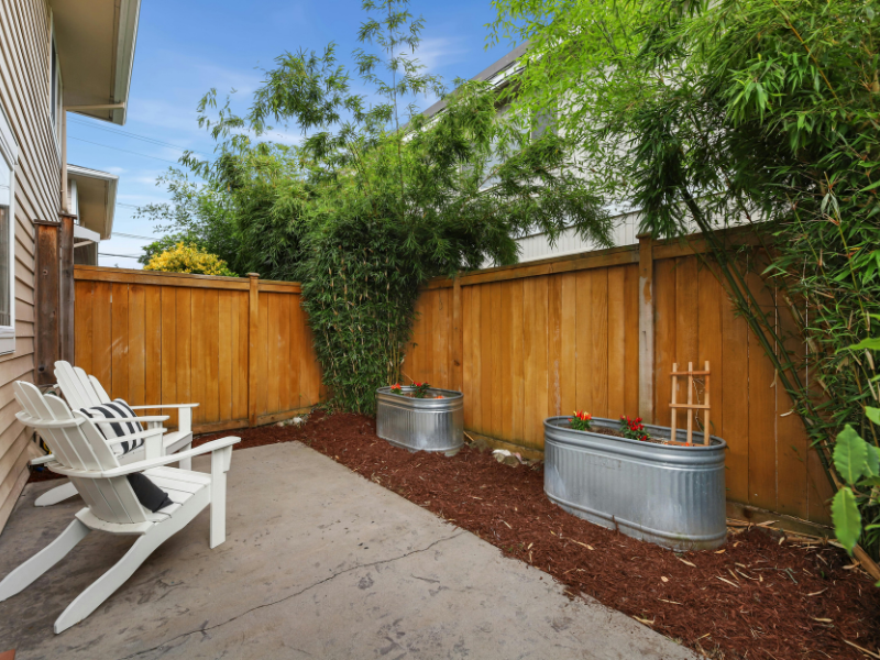 An image showing a private backyard with a tall wooden privacy fence.