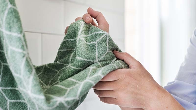 A man drying his hands with an Eco-friendly microfiber towel