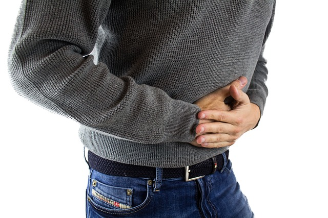 An image of a man holding his stomach in pain.