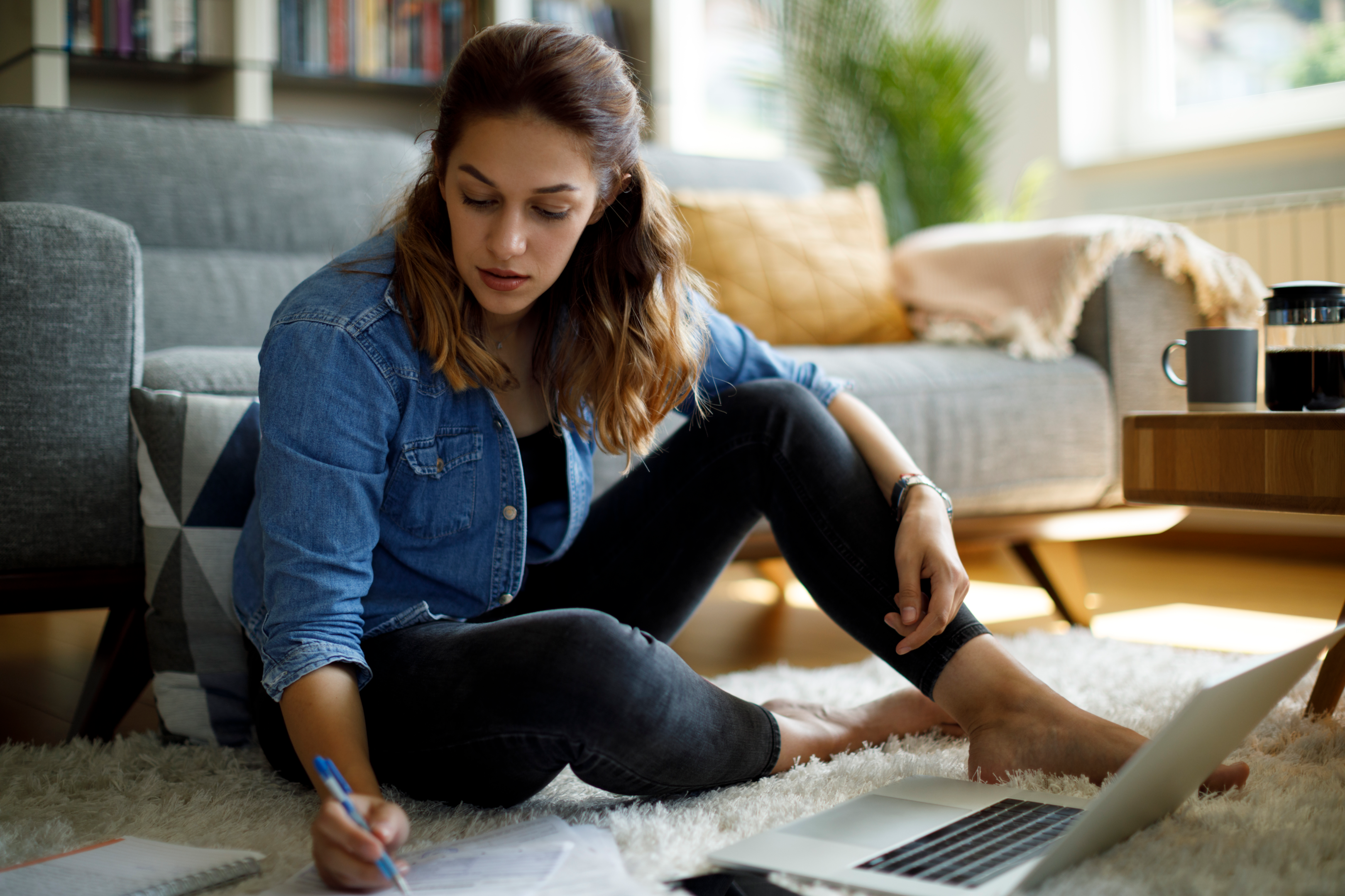 woman-sitting-on-floor-with-laptop-and-paper