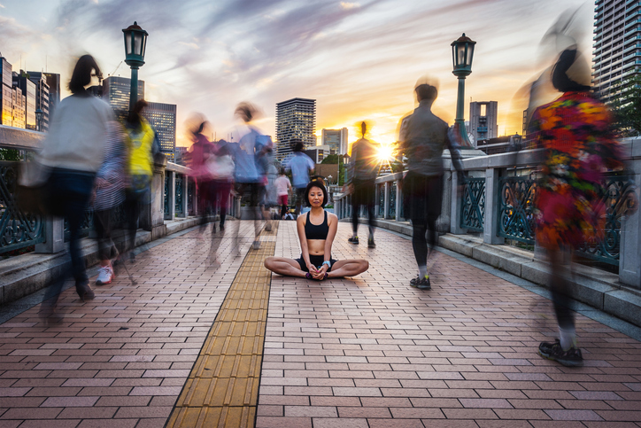 Woman sitting in a city meditating.
