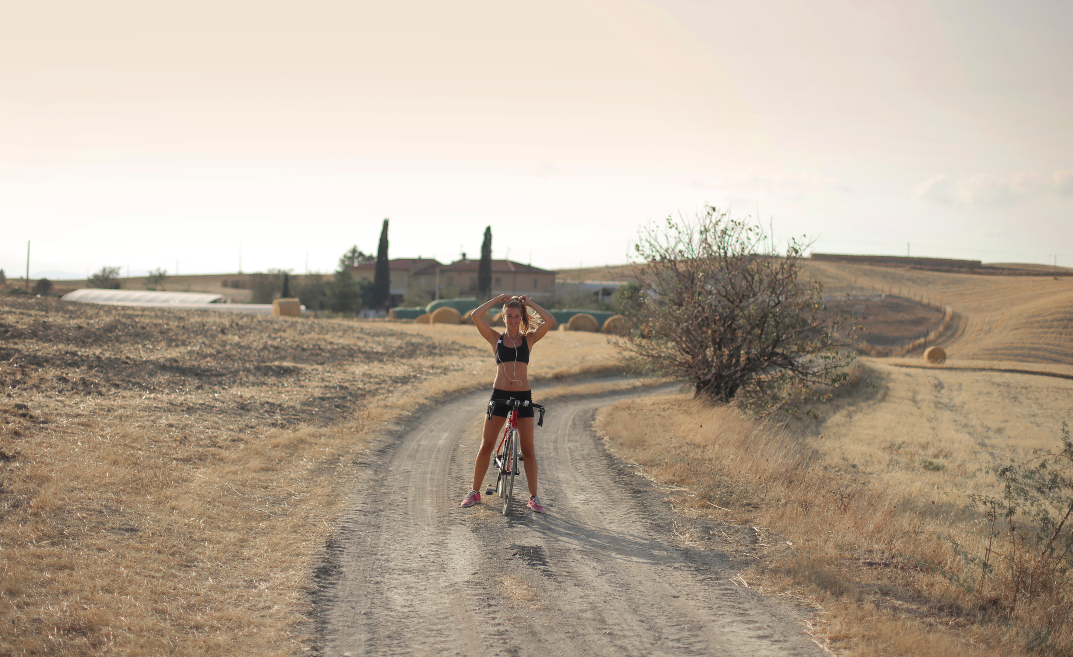 Jovem andando de bicicleta em uma estrada de terra. Foto de Andrea Piacquadio, Pexels.