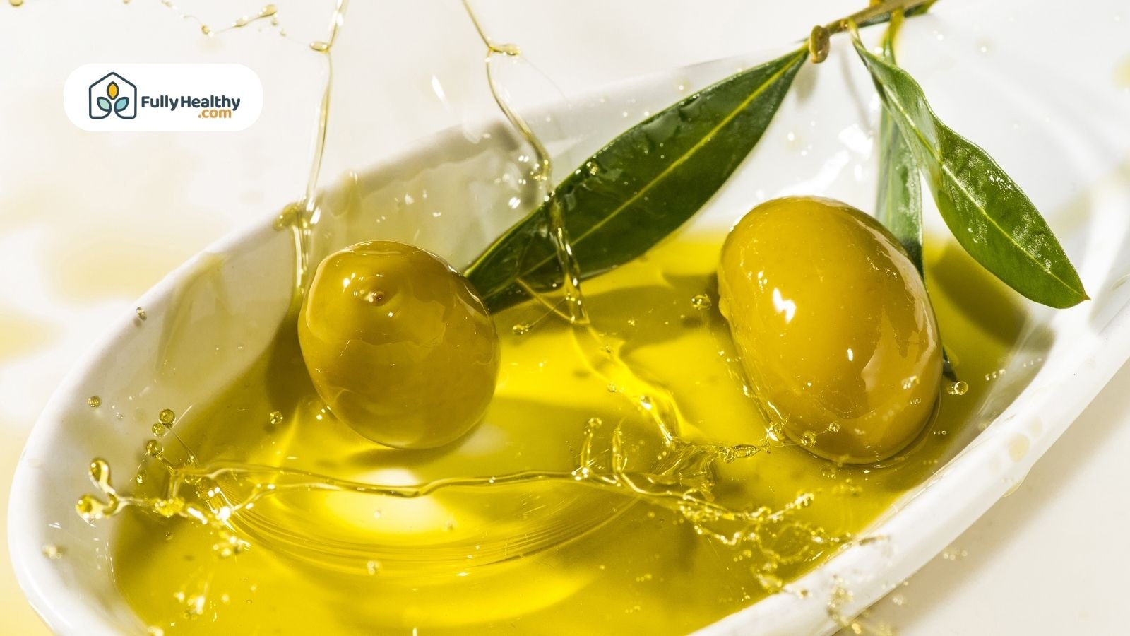 Close-up of green olives and oil splash in a white bowl