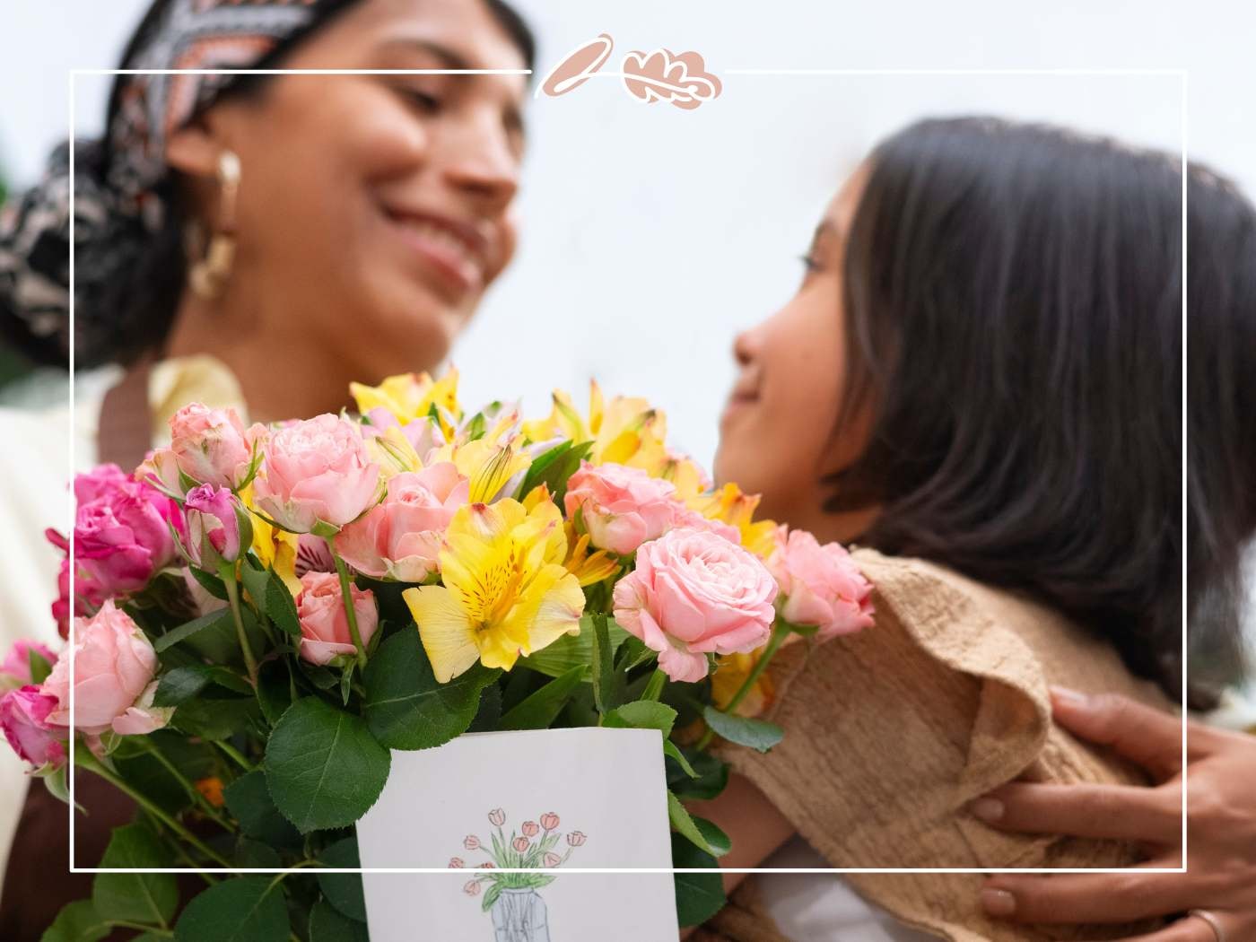 Pink and yellow birthday bouquet with card in foreground as daughter leans in to kiss mum — Fabulous Birthday Wishes for Mom.