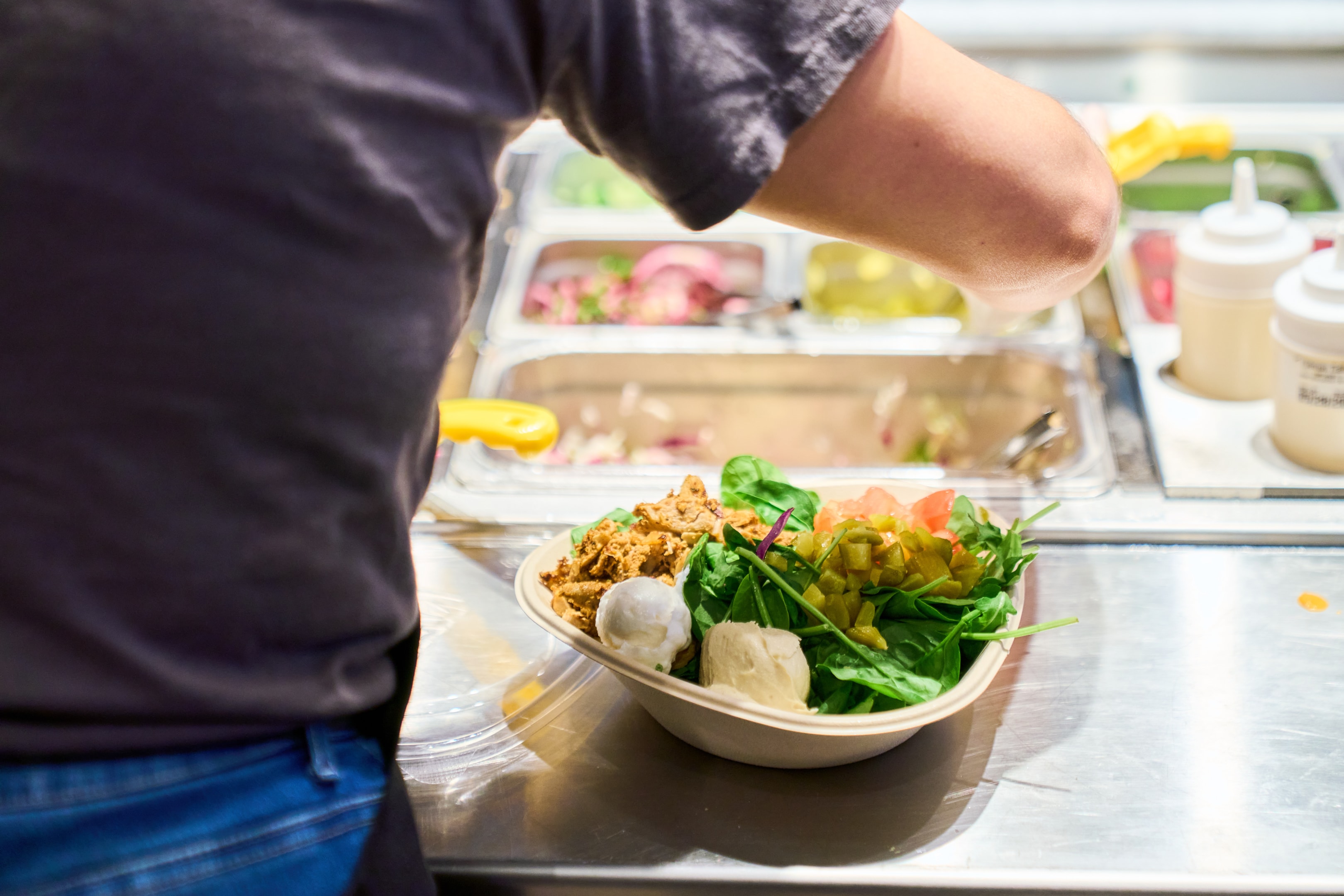 Naya chicken salad bowl being served by a team member at the Bryant Park restaurant. A great healthy lunch