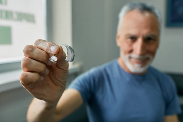 A person using a hearing aid to help with hearing loss caused by excess earwax