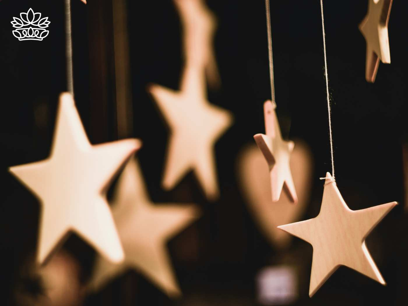 Wooden star ornaments hanging gracefully, symbolizing the surprise and joy of the season, an easy way to bring a festive touch to any house, and a charming addition to Christmas gifts, from the curated range at Fabulous Flowers and Gifts.