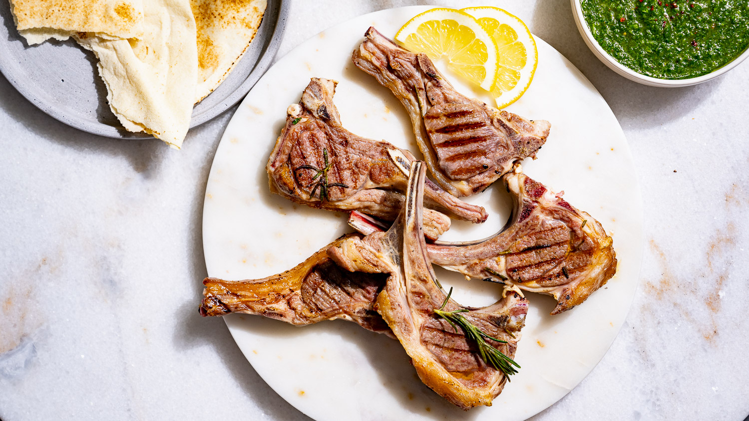 Grilled lamb chops - a serving suggestion with flatbread, zhug and lemon.