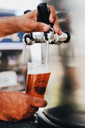 Bartender pouring a beer at one of the best Greenwich outdoor bars