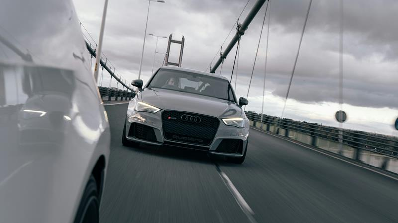 Audi car with LED headlights driving over bridge