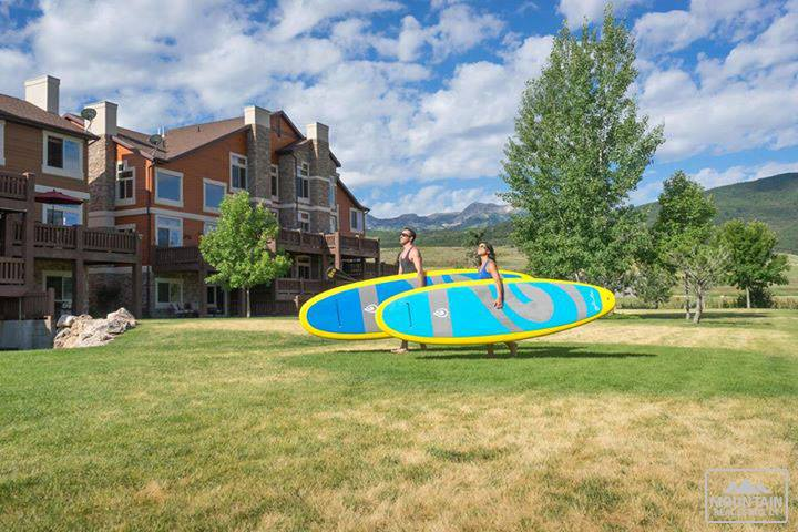 couple carrying paddle boards