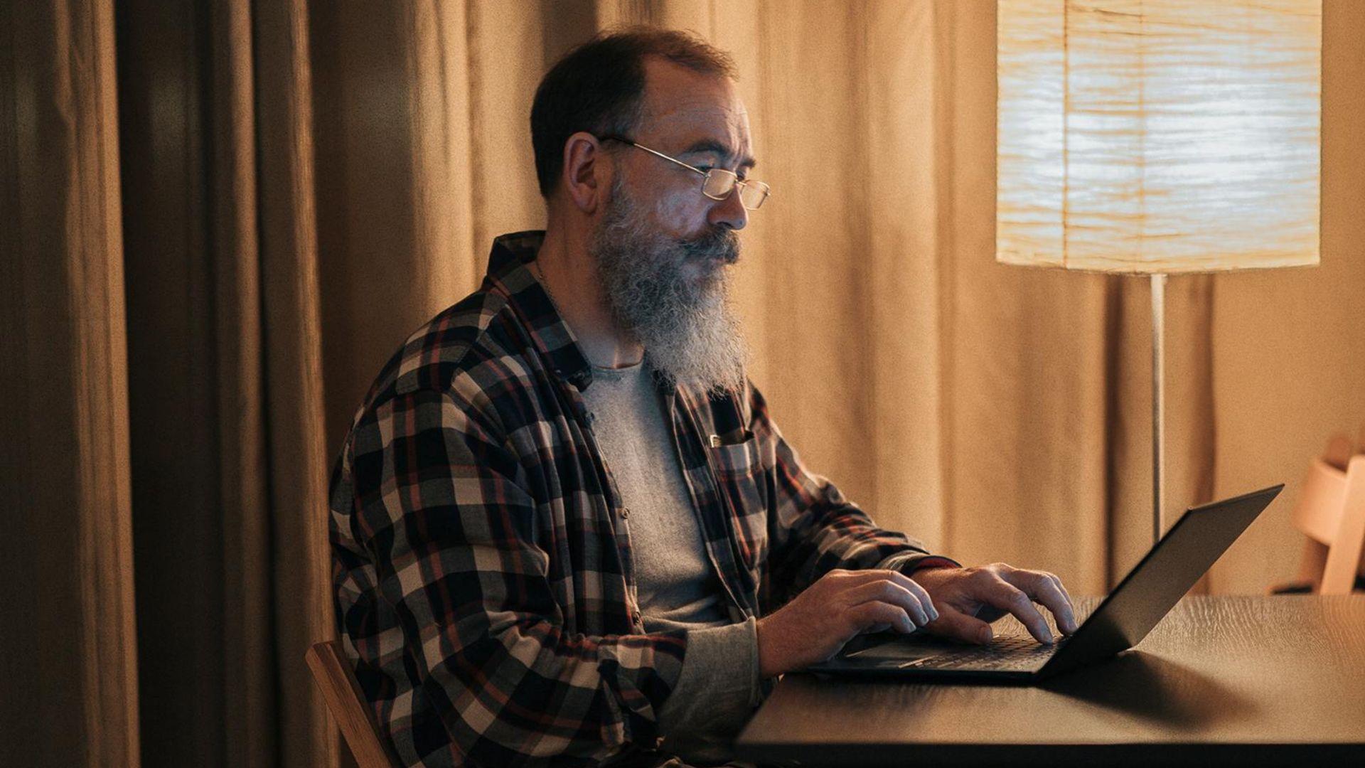 A man on a laptop preparing to sell some of his woodworking projects.