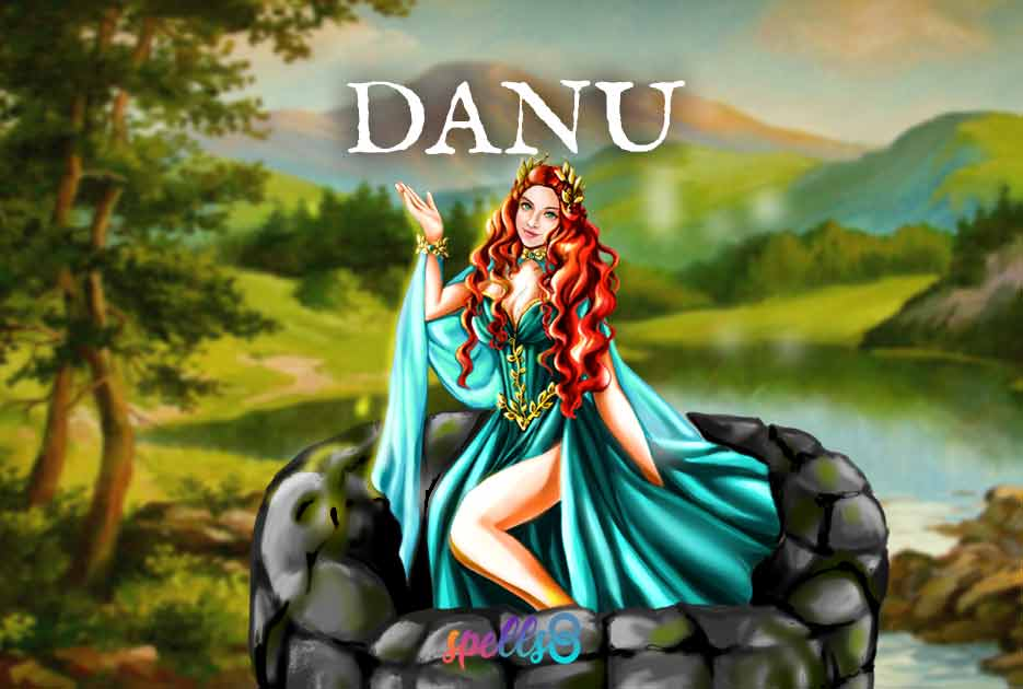 Danu is sitting at the top of a well in a blue dress adorned with gold as well as a gold crown on her red hair. The well is located near a small lake and mountains and trees surround it. 