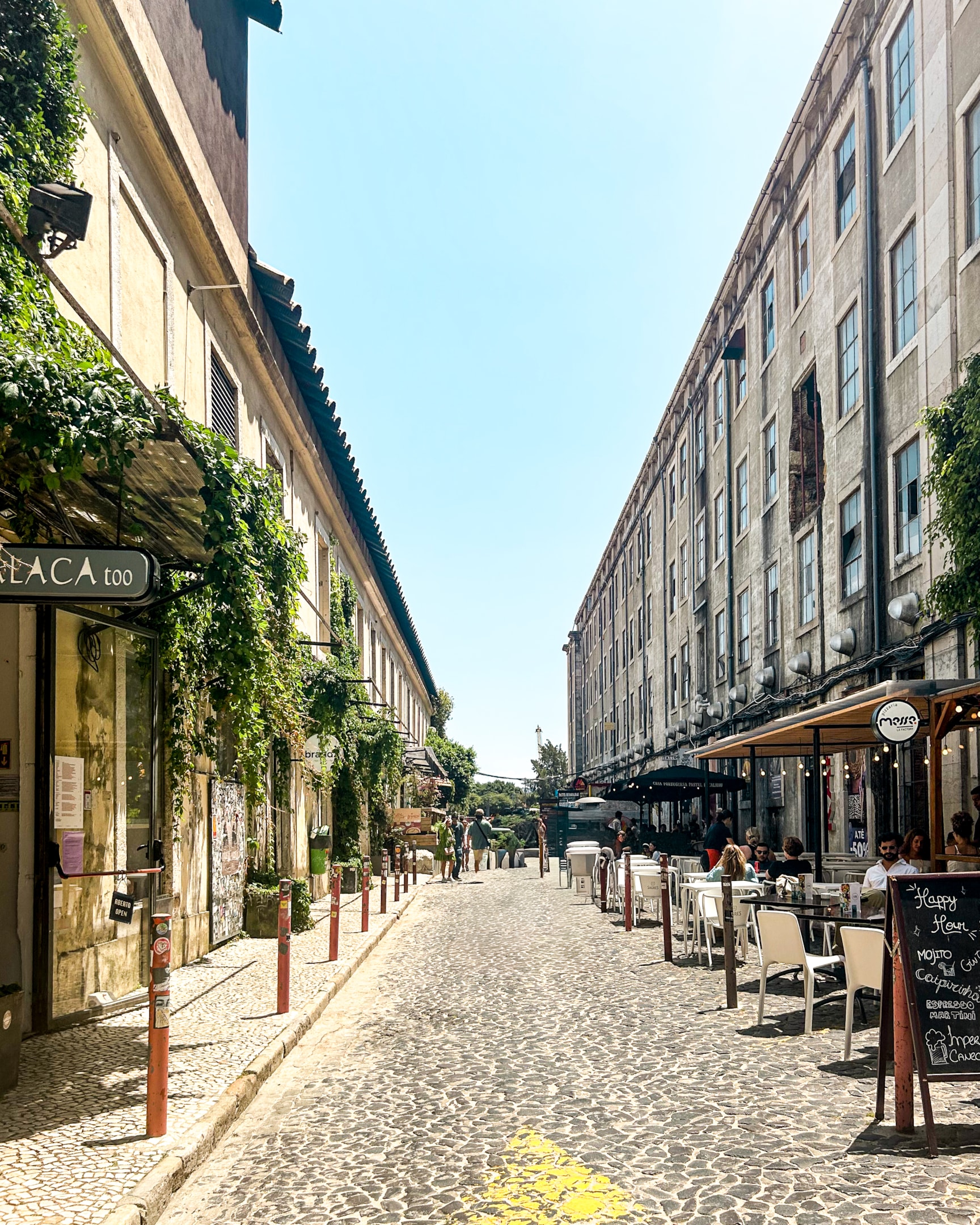 Where to stay in Lisbon neighborhood street in LX Factory in Lisbon, Portugal featuring people walking and people eating outside