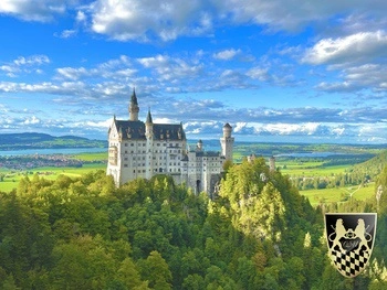 A stunning view of Neuschwanstein Castle, often referred to as "Sleeping Beauty's Castle," is perched majestically on a hillside surrounded by lush forests and towering mountains. This iconic structure, associated with King Ludwig II, offers a picturesque backdrop for visitors exploring the Bavarian countryside on a guided Neuschwanstein Castle tour.