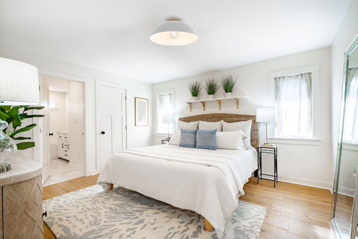 White dome flush mount ceiling light illuminating a bright neutral bedroom