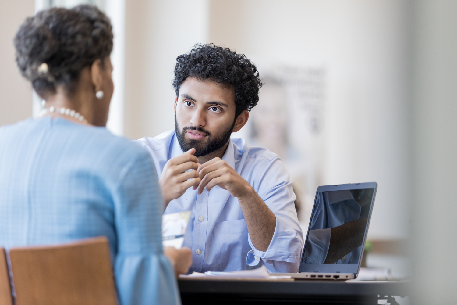 A small business owner sitting across from a banker at a desk.