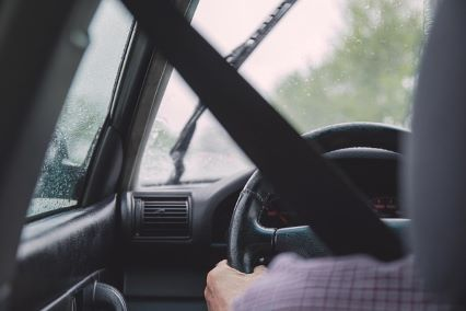 seatbelted driver with hands on steering wheel