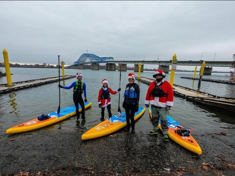 people next to inflatable stand up paddle boards