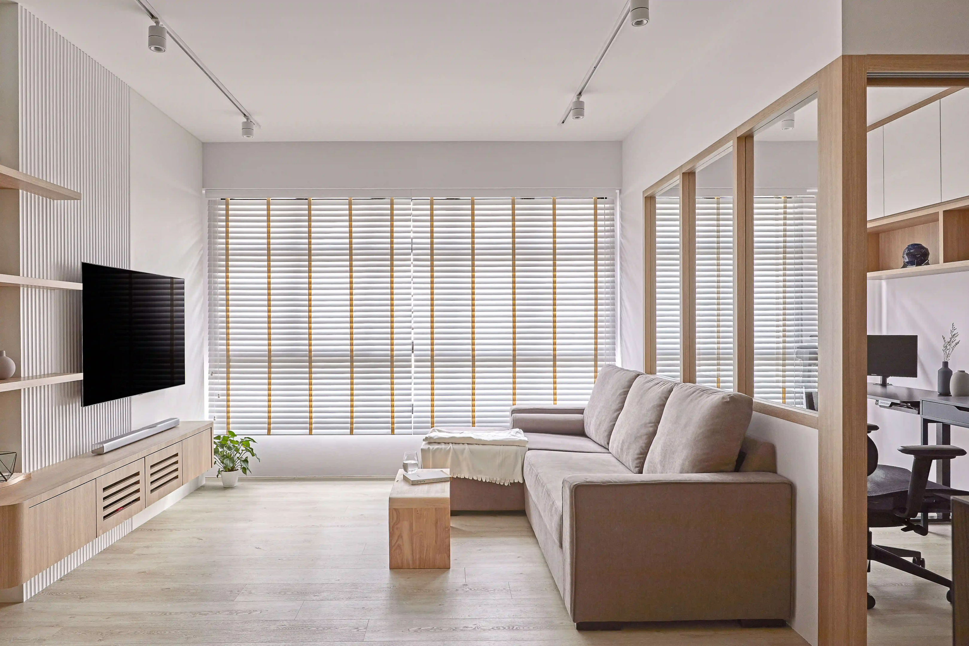 Light-filled minimalist lounge featuring track lights, timber-trim blinds and an integrated study nook in KL