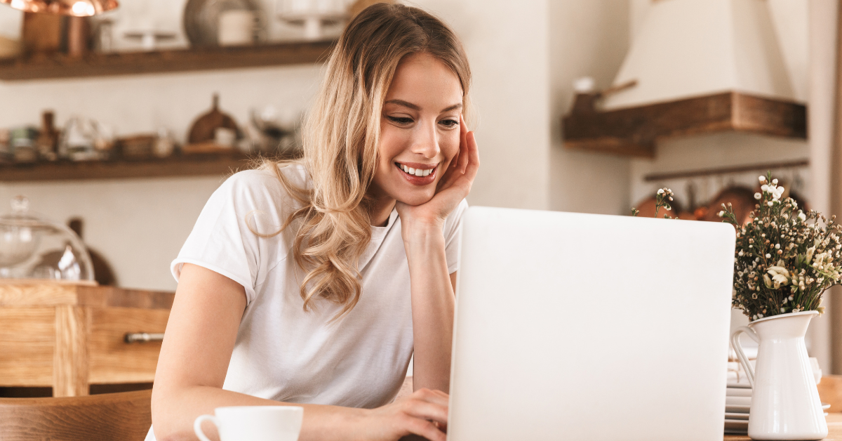 A woman looking at her laptop reading about the Onlyfans terms of service.